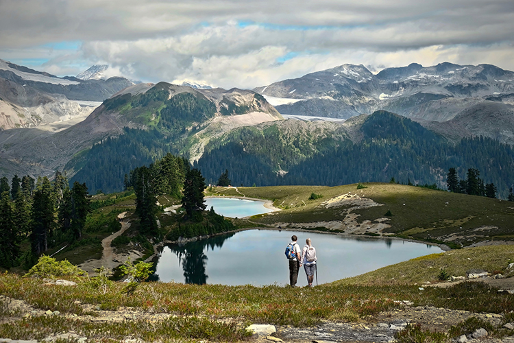 Br24 Blog Visual Trends 2019 - Natural Instinct: Two people in front of impressive mountain scenery with lakes and mountains