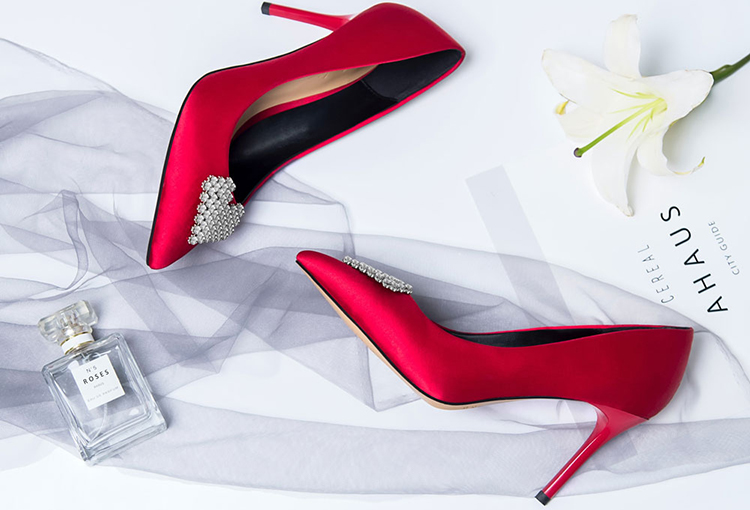 Br24 Produktbilder Accessoires: Rote High Heels auf weißem Hintergrund mit Parfümflakon, weisér Blume und Schleier als passende Accessoires