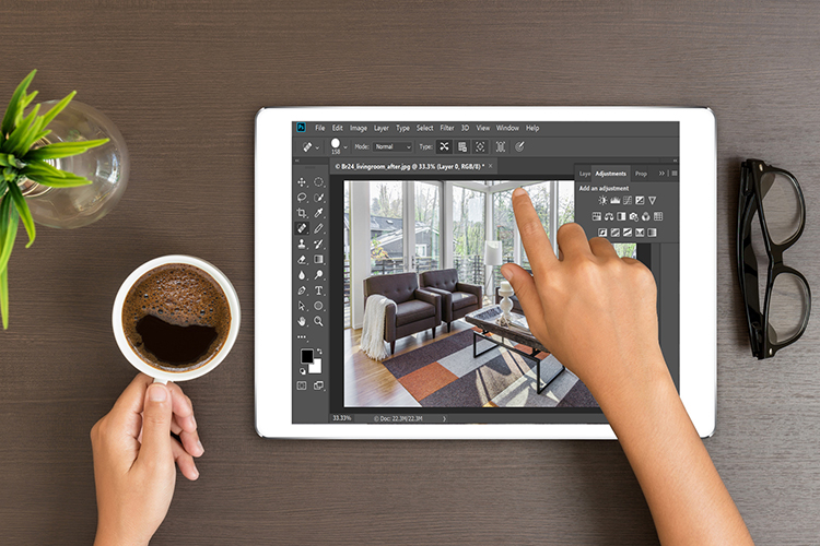 Br24 Blog Adobe Update für iPad: Ansicht eines Tablets mit Adobe Photoshop, Hände einer Person die auf dem Tablet ein Immobilienbild retuschiert