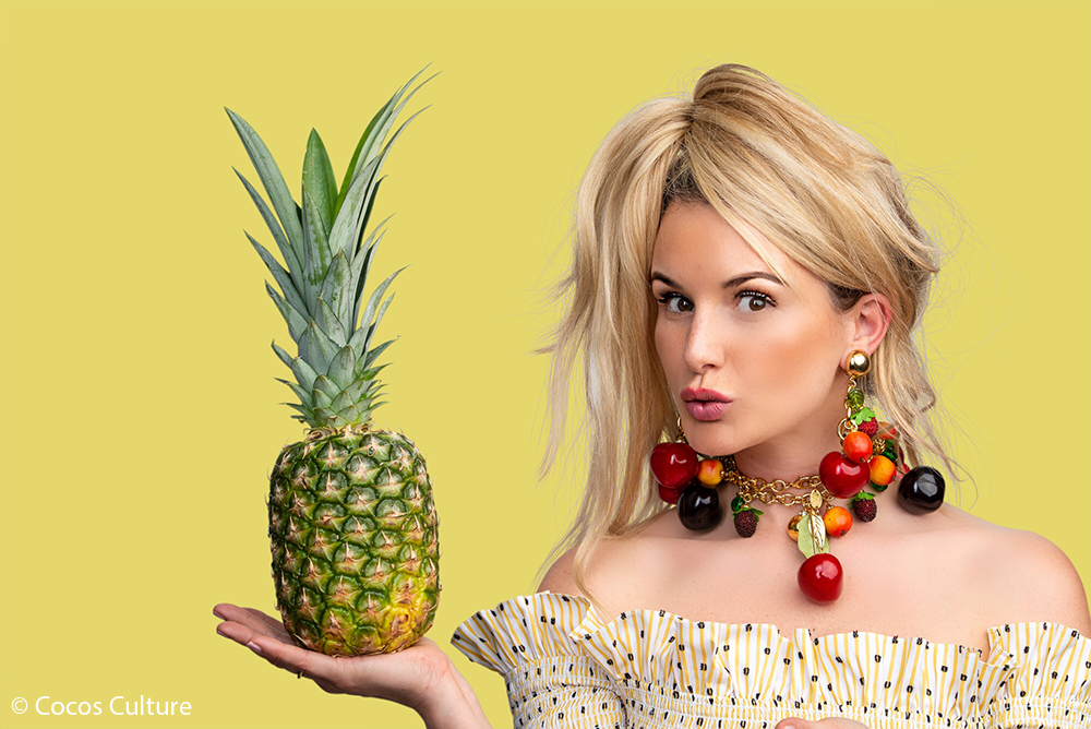 Br24 Werbung & Marketing, Hintergrund entfernen: Porträt einer Frau mit einer Ananas in der Hand vor gelbem Hintergrund